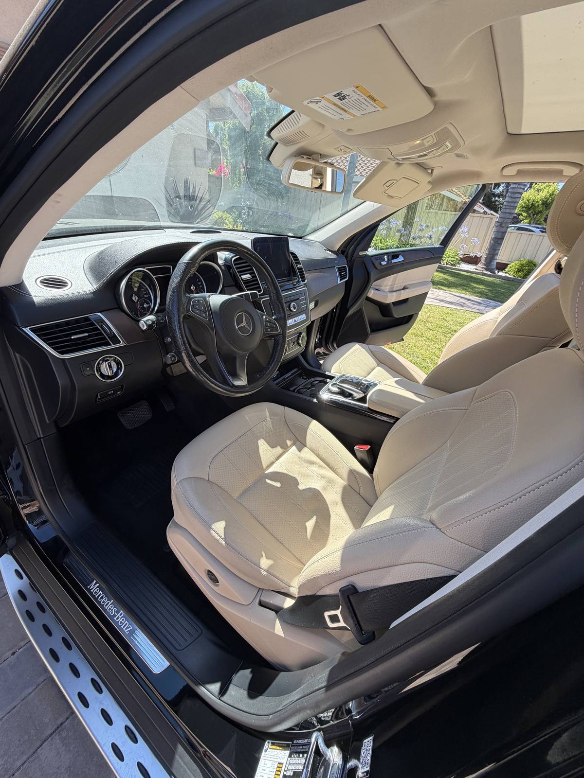 Full interior detail of a Mercedes-Benz with cream leather seats and dashboard