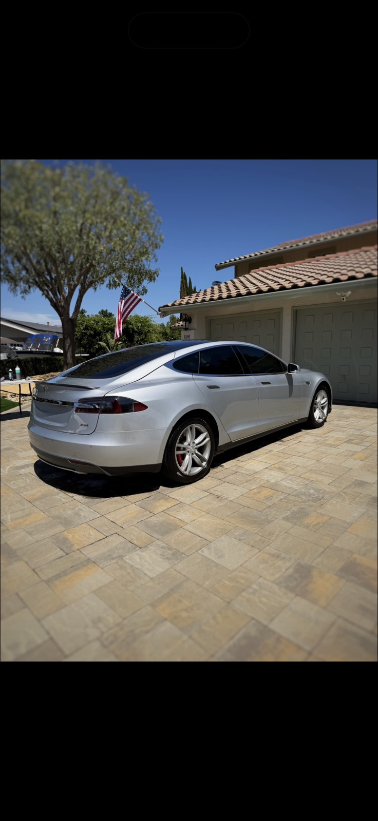 Silver Tesla Model S with a mirror-gloss finish parked in a driveway