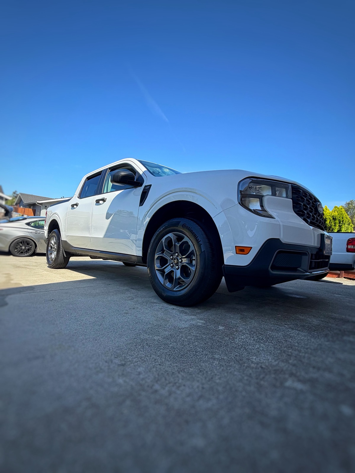 Detailed alloy wheel and dressed tire on a white Ford Maverick